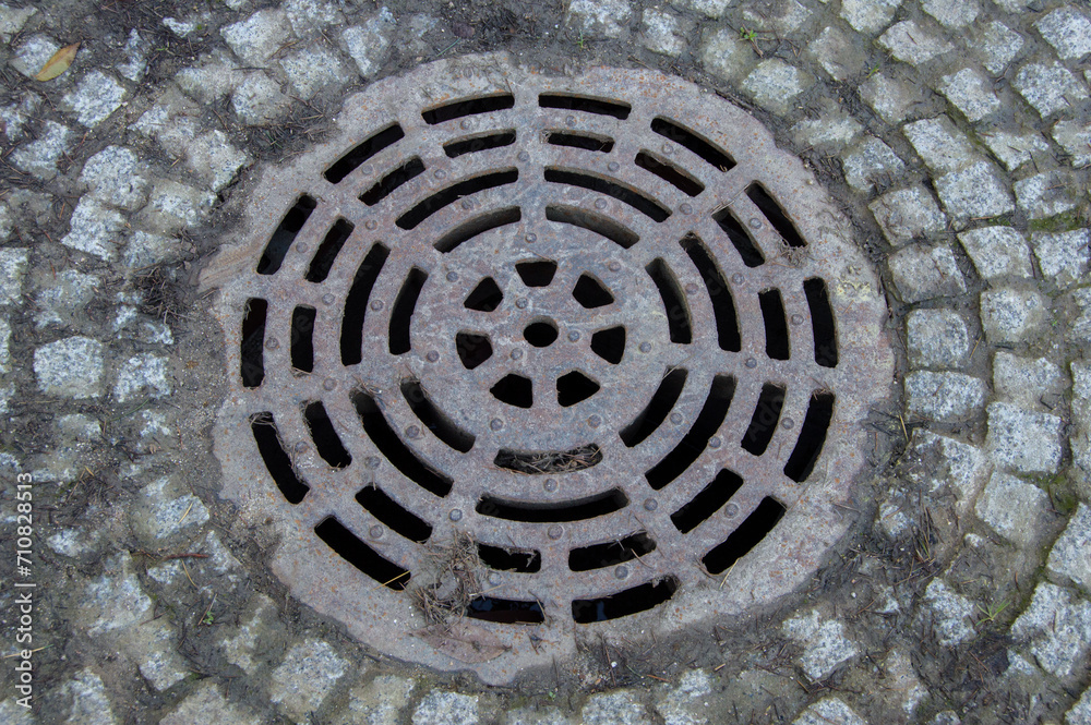 background with drain surrounded by cobblestones in a street