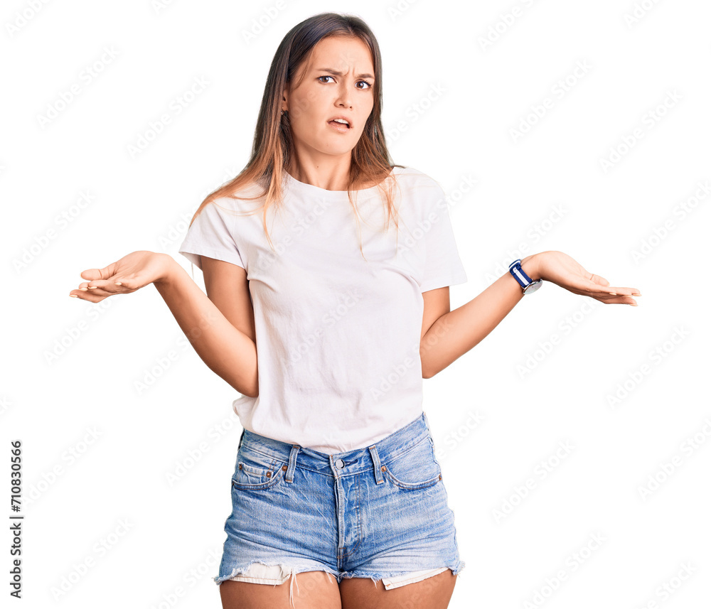 Beautiful caucasian woman wearing casual white tshirt clueless and confused with open arms, no idea concept. Beautiful caucasian woman wearing casual white tshirt clueless and confused with open arms, no idea concept.