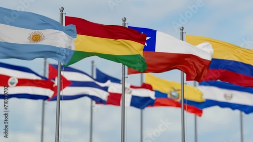 Latin America region country flags waving together on cloudy sky, endless seamless loop