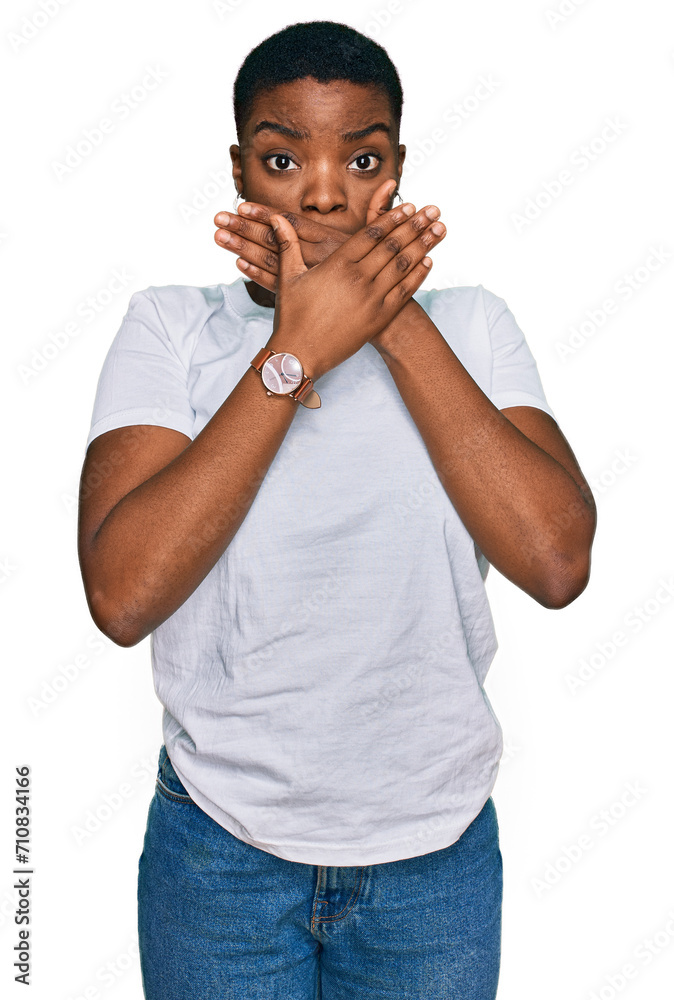 Young african american woman wearing casual white t shirt shocked covering mouth with hands for mistake. secret concept. Young african american woman wearing casual white t shirt shocked covering mouth with hands for mistake. secret concept.