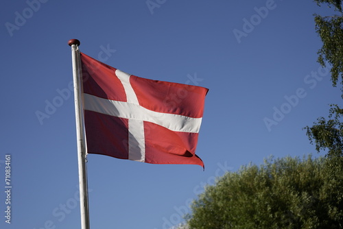 Flag of Denmark, Denmark flag isolated on the blue sky with clipping path. close up waving flag of Denmark. flag symbols of Denmark.