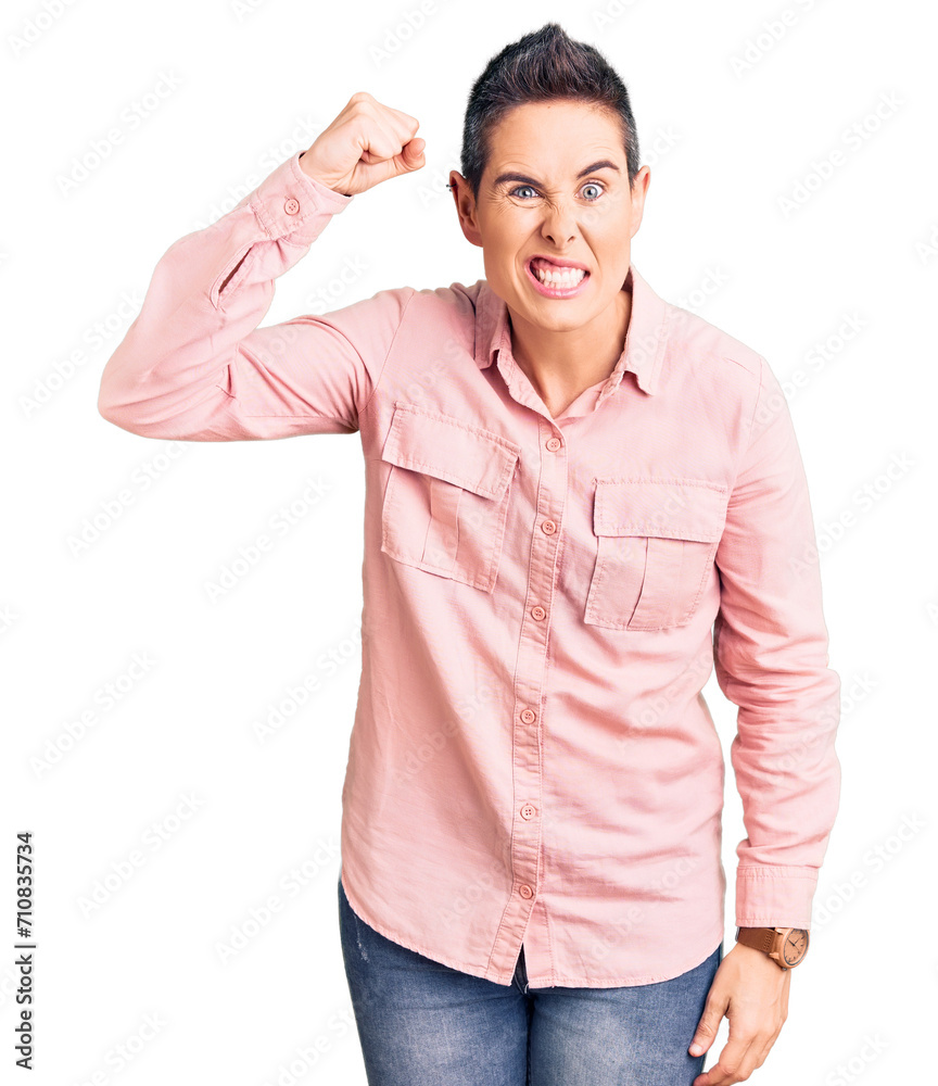 Young woman with short hair wearing casual clothes angry and mad raising fist frustrated and furious while shouting with anger. rage and aggressive concept. Young woman with short hair wearing casual clothes angry and mad raising fist frustrated and furious while shouting with anger. rage and aggressive concept.