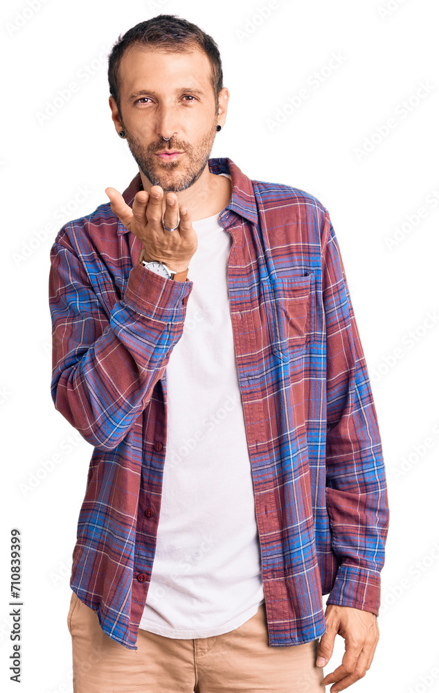 Young handsome man wearing casual clothes looking at the camera blowing a kiss with hand on air being lovely and sexy. love expression. Young handsome man wearing casual clothes looking at the camera blowing a kiss with hand on air being lovely and sexy. love expression.