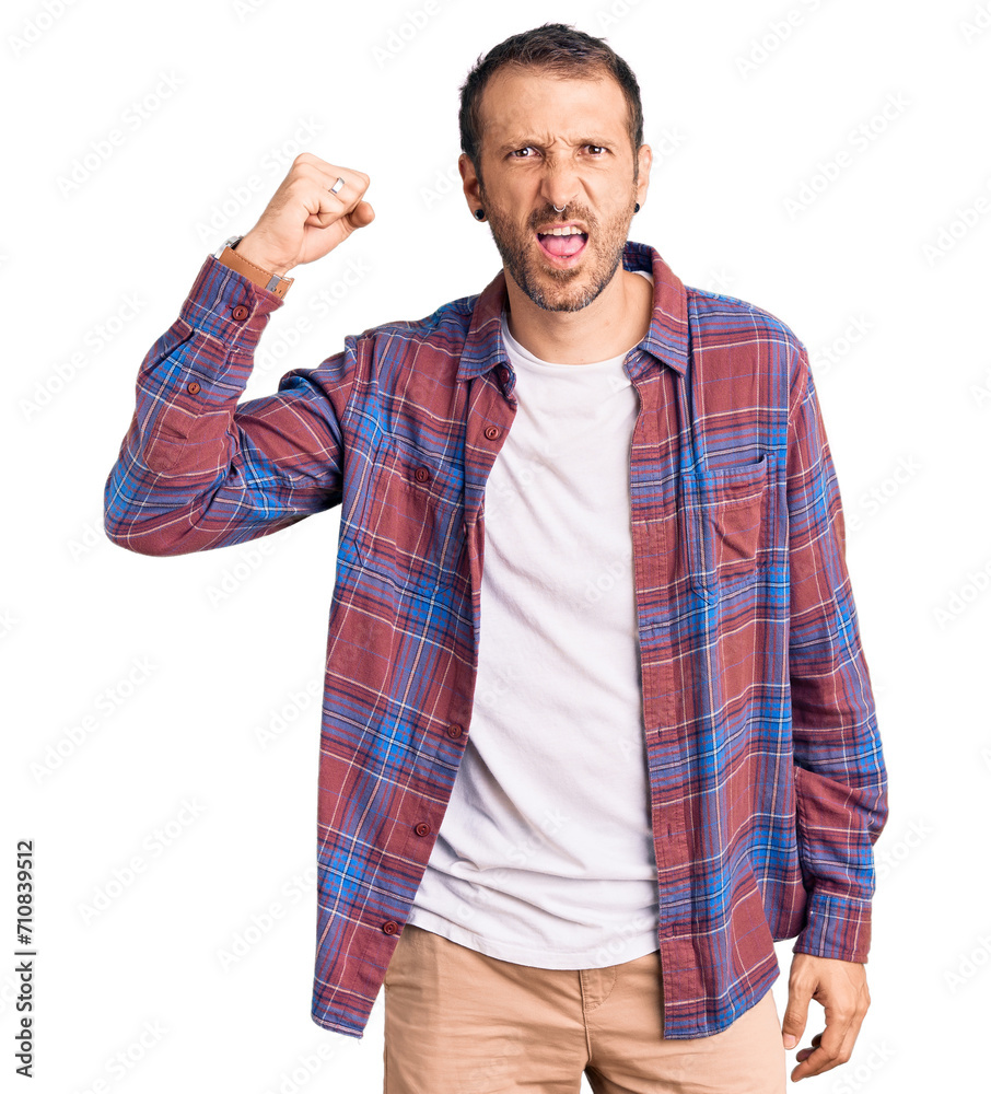 Young handsome man wearing casual clothes angry and mad raising fist frustrated and furious while shouting with anger. rage and aggressive concept. Young handsome man wearing casual clothes angry and mad raising fist frustrated and furious while shouting with anger. rage and aggressive concept.
