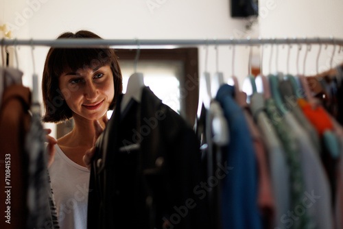 Home wardrobe or dressing room of a clothing store. a young woman chooses a fashionable outfit in her closet at home or in a store.