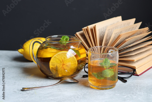 Still life with mint and lemon tea and open book on a table. Cozy winter day at home. 