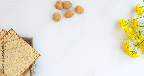 atza in a silver plate, with nuts and yellow flowers. Passover elements for a blessing and a greeting card. top view of matza,
jewish Passover (Pesach)
 holiday concept
with free space for text photo