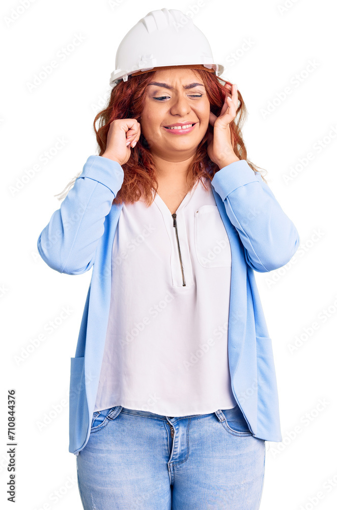 Young latin woman wearing architect hardhat covering ears with fingers with annoyed expression for the noise of loud music. deaf concept. Young latin woman wearing architect hardhat covering ears with fingers with annoyed expression for the noise of loud music. deaf concept.