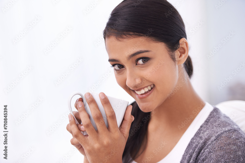 Coffee, relax and portrait of Indian woman on sofa for wellness, comfortable and calm in home. Apartment, morning and happy person with mug drinking hot beverage, tea and caffeine in living room Coffee, relax and portrait of Indian woman on sofa for wellness, comfortable and calm in home. Apartment, morning and happy person with mug drinking hot beverage, tea and caffeine in living room