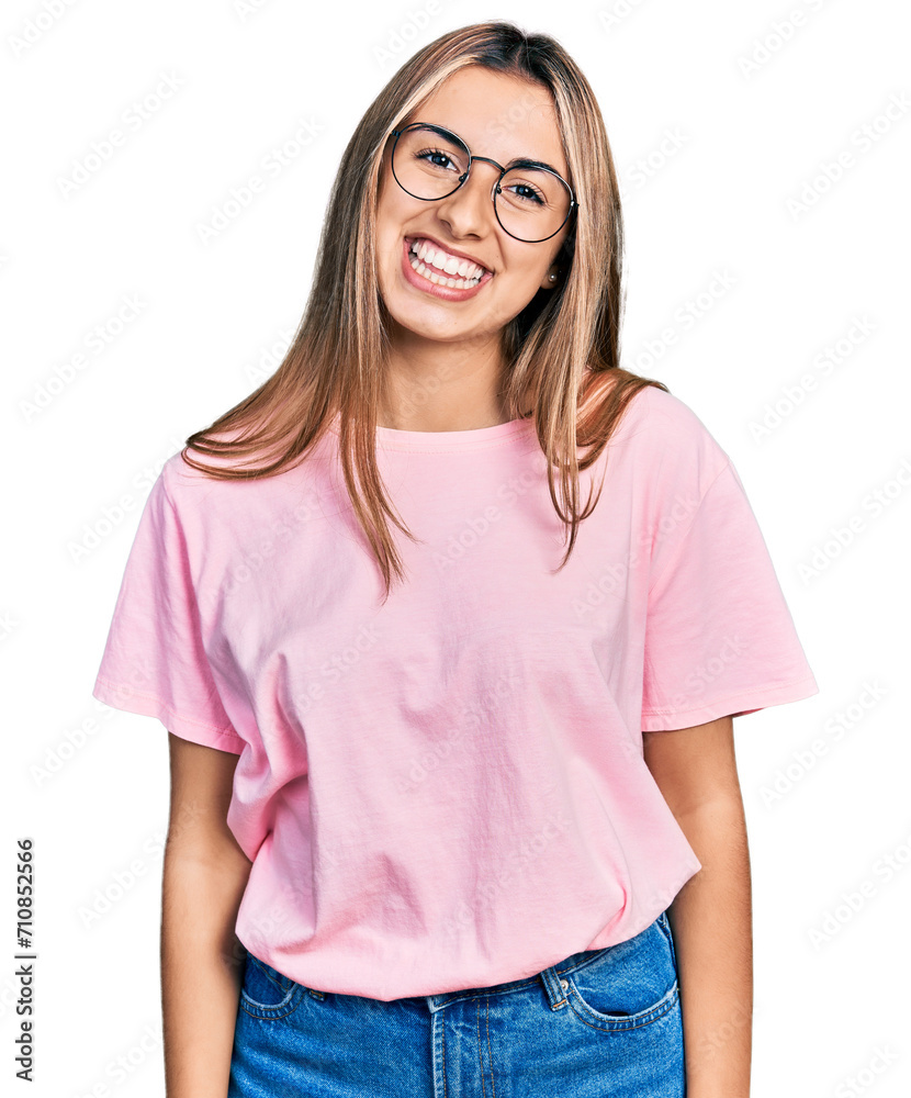 Hispanic young woman wearing casual t shirt and glasses looking positive and happy standing and smiling with a confident smile showing teeth Hispanic young woman wearing casual t shirt and glasses looking positive and happy standing and smiling with a confident smile showing teeth