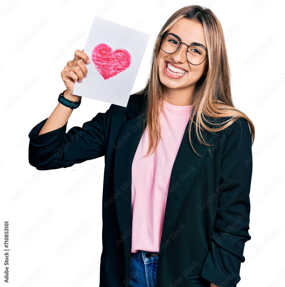 Hispanic young woman holding heart draw looking positive and happy standing and smiling with a confident smile showing teeth Hispanic young woman holding heart draw looking positive and happy standing and smiling with a confident smile showing teeth