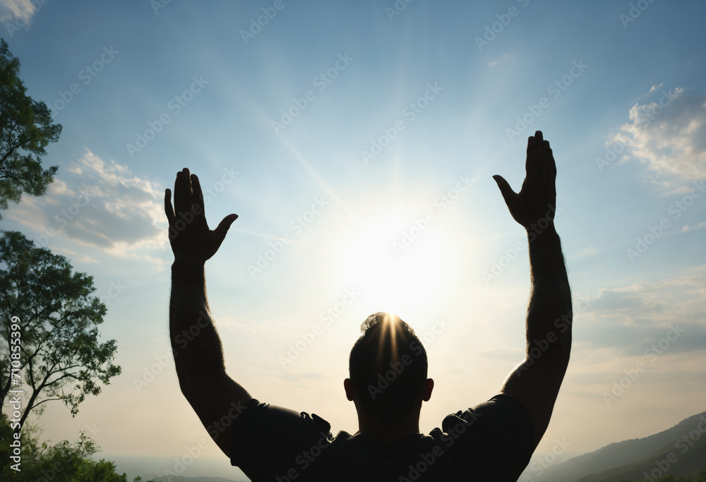 Silhouette of man worship with hands raised to the sky in nature Silhouette of man worship with hands raised to the sky in nature