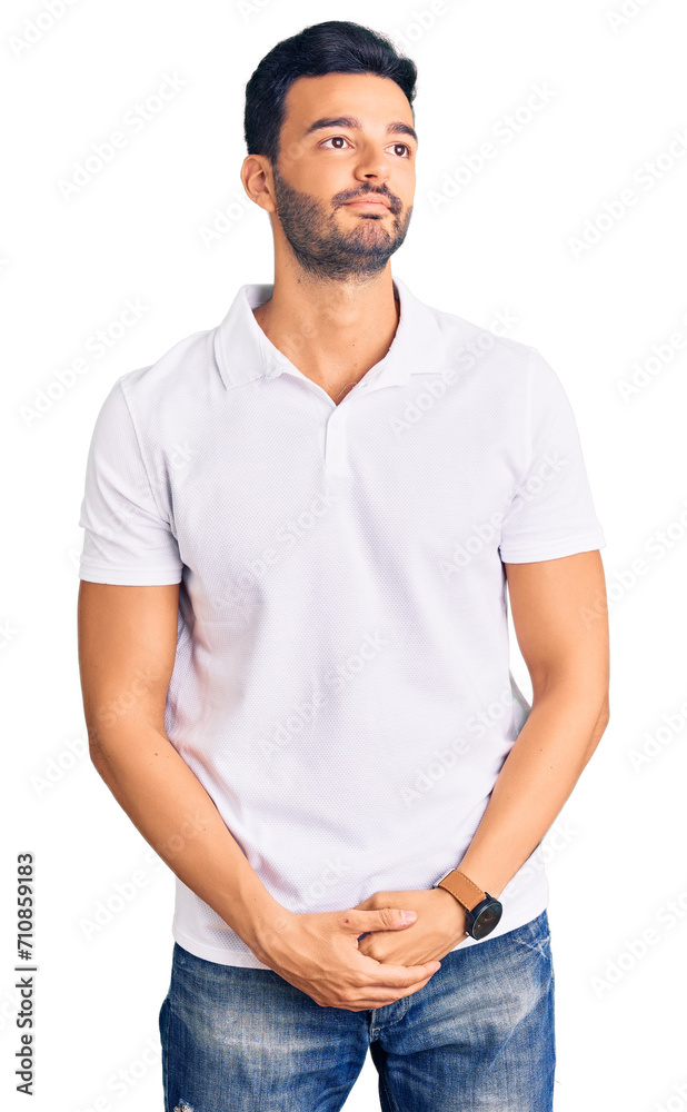 Young handsome hispanic man wearing casual clothes smiling looking to the side and staring away thinking. Young handsome hispanic man wearing casual clothes smiling looking to the side and staring away thinking.