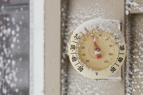 Snow Capped Thermometer Mounted on Wooden Siding of House Showing Freezing Temperatures