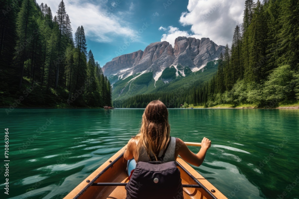 A woman peacefully sits in a boat, enjoying the calmness of a serene lake, Beautiful woman kayaking on a stunning mountain lake surrounded by green trees, AI Generated