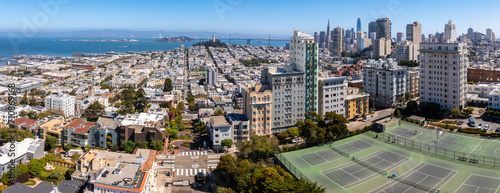 Panoramic view of aerial Lombard Street, an east west street in San Francisco, California. Famous for steep, one block section with eight hairpin turns. Tennis courts in San Francisco.