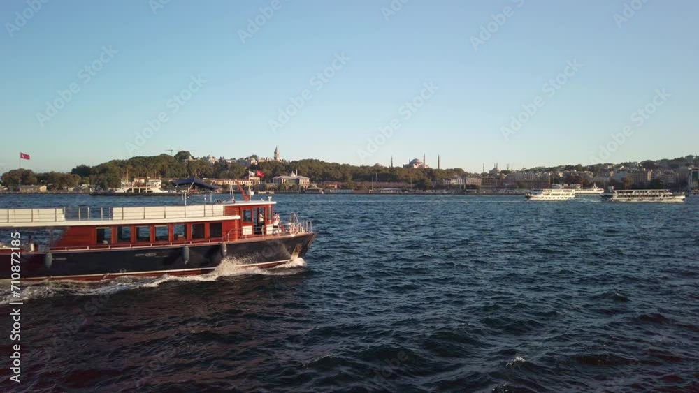 Evening, cinematic slow-mo, picturesque view of Sarayburnu from ferry on Golden Horn in Istanbul. Shot showcases ferry sailing right to left, Hagia Sophia, cityscape, and Sirkeci Port in background. Evening, cinematic slow-mo, picturesque view of Sarayburnu from ferry on Golden Horn in Istanbul. Shot showcases ferry sailing right to left, Hagia Sophia, cityscape, and Sirkeci Port in background.