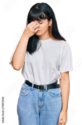 Young hispanic girl wearing casual clothes tired rubbing nose and eyes feeling fatigue and headache. stress and frustration concept.