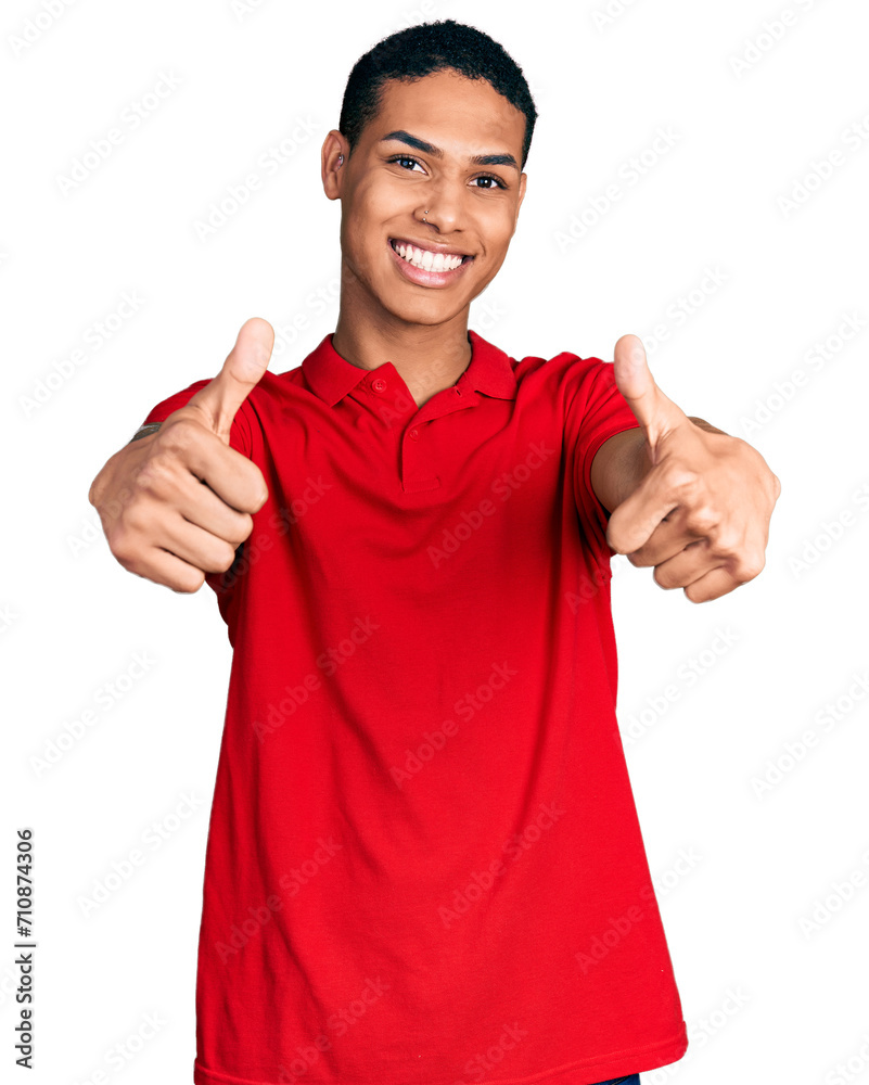 Young hispanic man wearing casual red t shirt approving doing positive gesture with hand, thumbs up smiling and happy for success. winner gesture. Young hispanic man wearing casual red t shirt approving doing positive gesture with hand, thumbs up smiling and happy for success. winner gesture.