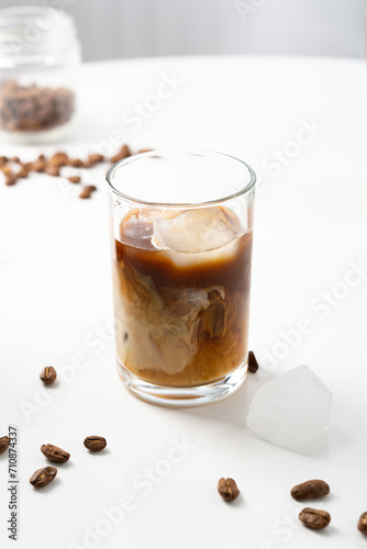 One glass cold iced coffee beverge with milk on light table