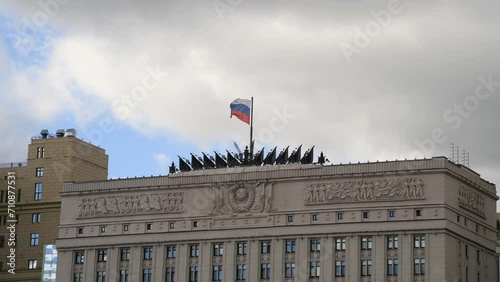 Russian national flag swaying on flagpole on top of Ministry of Defence of the Russian Federation building in a cloudy day in Moscow, Russia. Soft focus. Real time handheld video. Russian military.