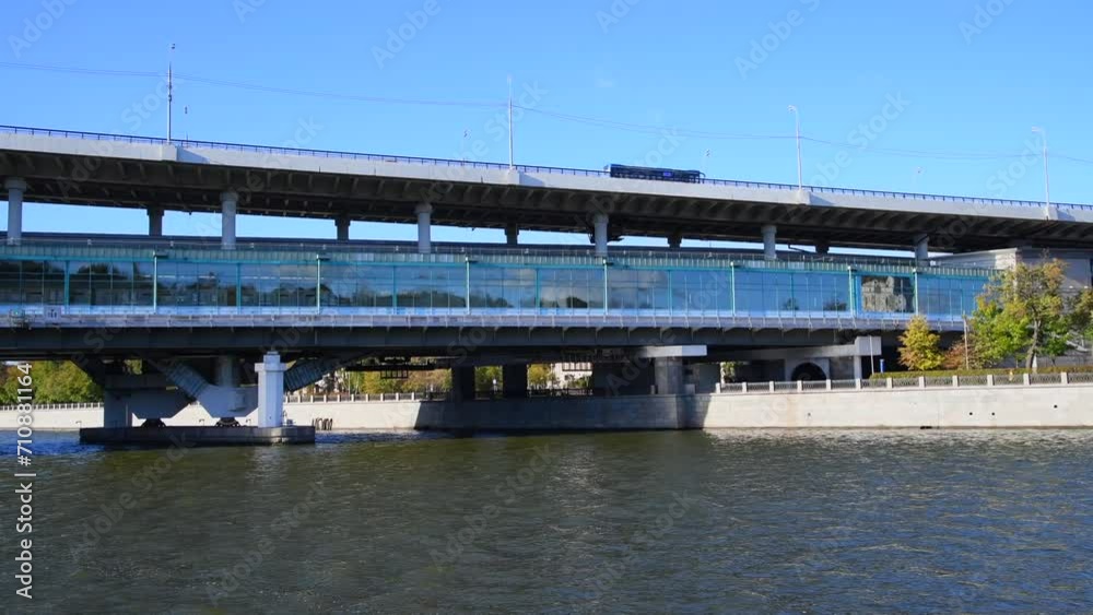 City view from tour boat sailing next to bridge with railway station on Moskva river in a sunny autumn day in Moscow, Russia. Soft focus. Real time handheld video. Water travel theme. City view from tour boat sailing next to bridge with railway station on Moskva river in a sunny autumn day in Moscow, Russia. Soft focus. Real time handheld video. Water travel theme.