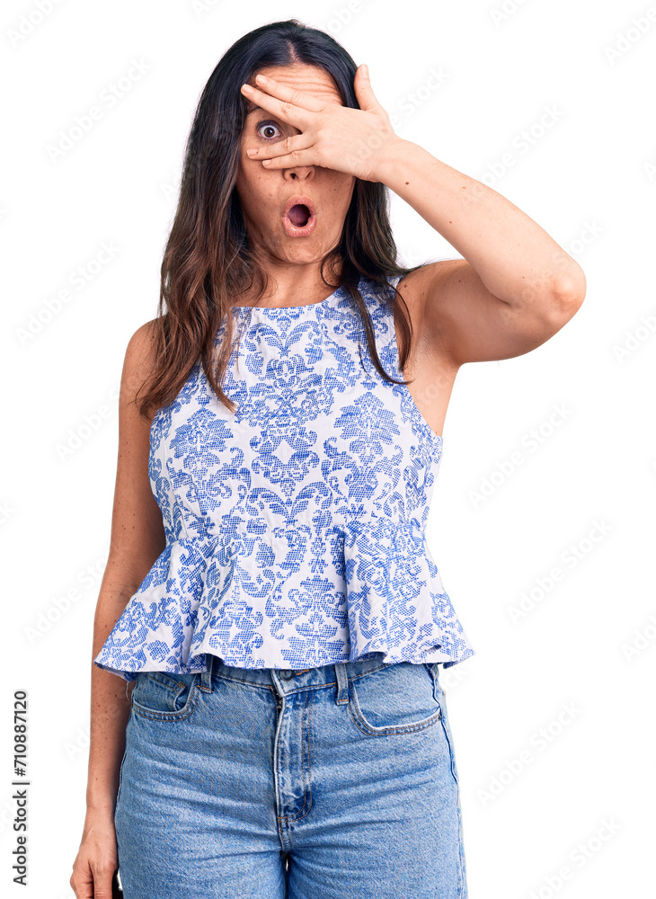 Young beautiful brunette woman wearing casual t-shirt peeking in shock covering face and eyes with hand, looking through fingers with embarrassed expression. Young beautiful brunette woman wearing casual t-shirt peeking in shock covering face and eyes with hand, looking through fingers with embarrassed expression.