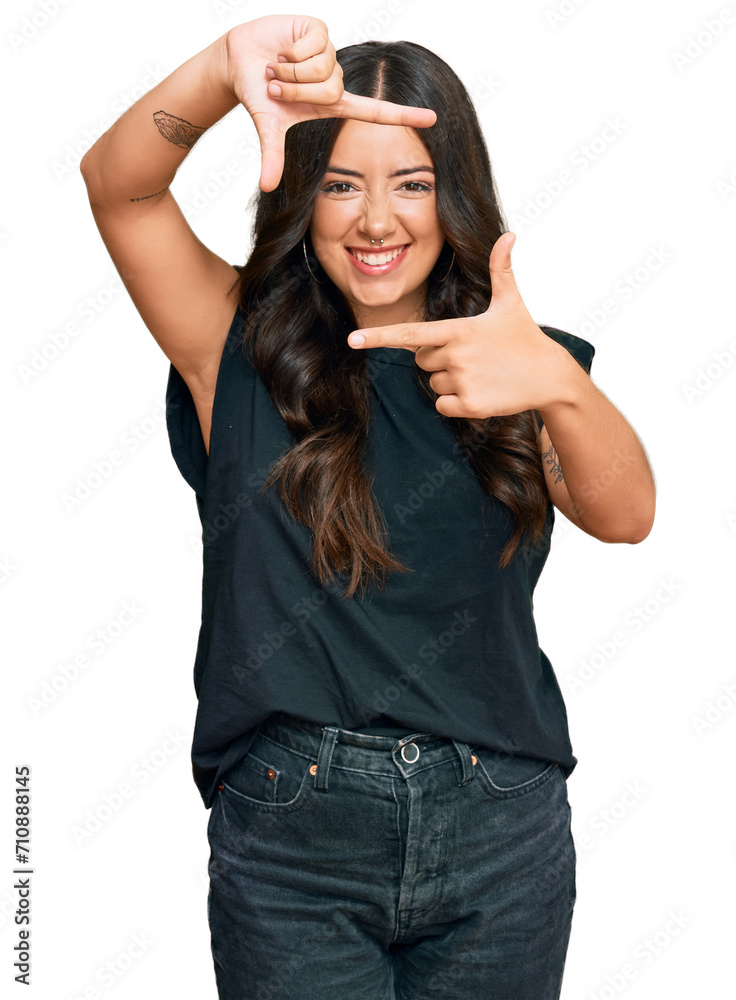 Beautiful brunette young woman wearing black shirt smiling making frame with hands and fingers with happy face. creativity and photography concept. Beautiful brunette young woman wearing black shirt smiling making frame with hands and fingers with happy face. creativity and photography concept.