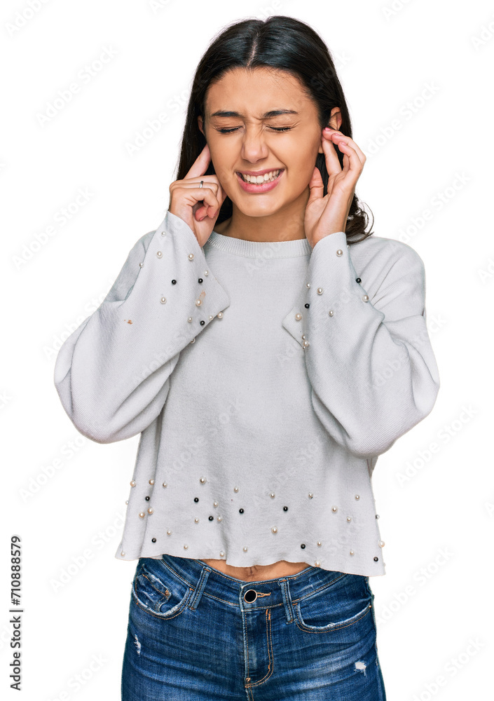 Young hispanic girl wearing casual clothes covering ears with fingers with annoyed expression for the noise of loud music. deaf concept. Young hispanic girl wearing casual clothes covering ears with fingers with annoyed expression for the noise of loud music. deaf concept.