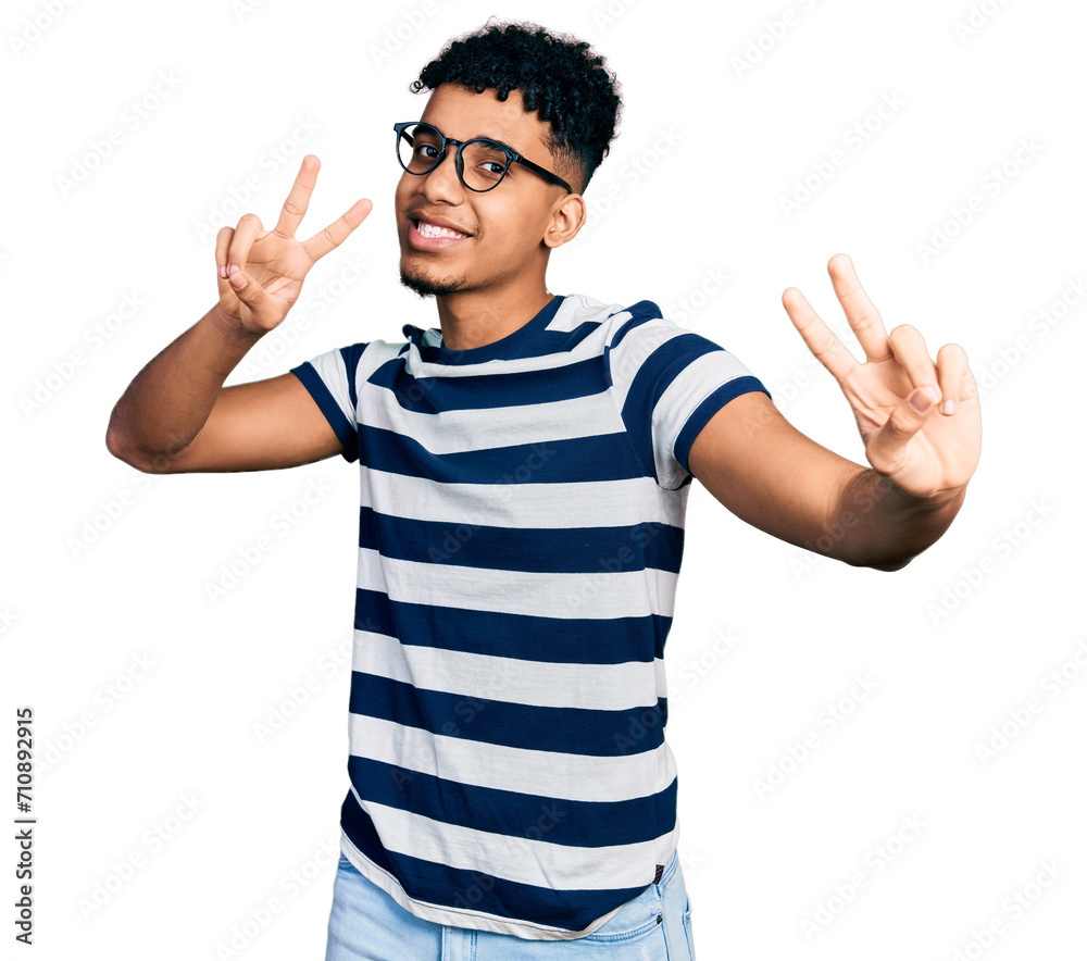 Young african american man wearing casual clothes and glasses smiling looking to the camera showing fingers doing victory sign. number two. Young african american man wearing casual clothes and glasses smiling looking to the camera showing fingers doing victory sign. number two.