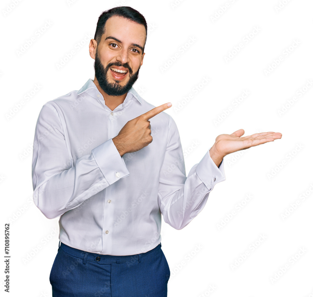 Young man with beard wearing business shirt amazed and smiling to the camera while presenting with hand and pointing with finger. Young man with beard wearing business shirt amazed and smiling to the camera while presenting with hand and pointing with finger.