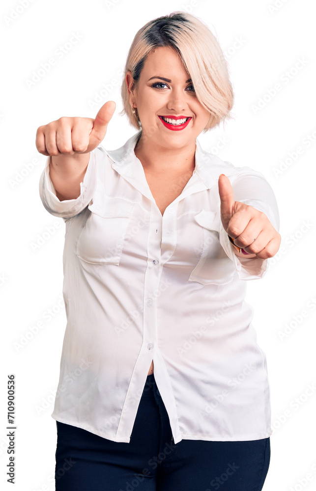 Young blonde plus size woman wearing casual shirt approving doing positive gesture with hand, thumbs up smiling and happy for success. winner gesture. Young blonde plus size woman wearing casual shirt approving doing positive gesture with hand, thumbs up smiling and happy for success. winner gesture.