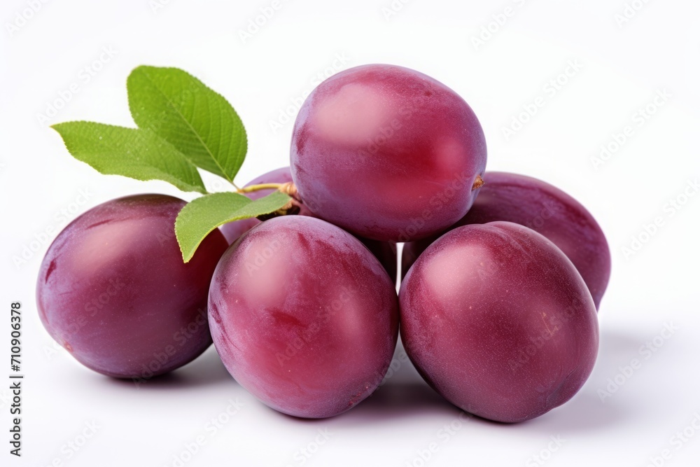 Fototapeta premium purple plum isolated on a white background. violet fruit, a bunch of berries with leaves.