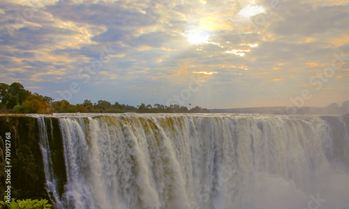Picturesque celestial landscape with the rays of the morning sun over Victoria Falls.