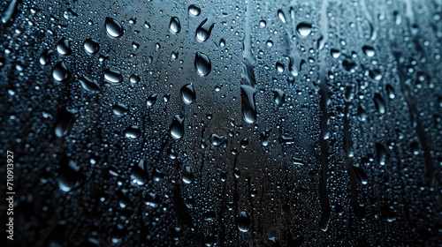 numerous shiny raindrops on a dark window glass. close-up or macro photography showing the intricate details of each drop and their reflections.