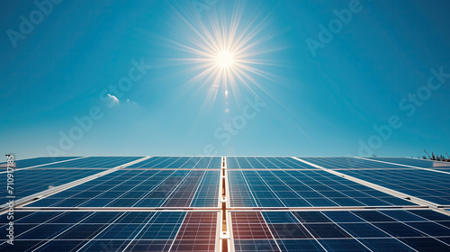 Solar panels with the sun shining brightly above. Clean and modern energy concept. © Tida
