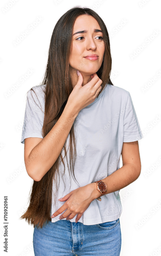Young hispanic girl wearing casual white t shirt touching painful neck, sore throat for flu, clod and infection Young hispanic girl wearing casual white t shirt touching painful neck, sore throat for flu, clod and infection