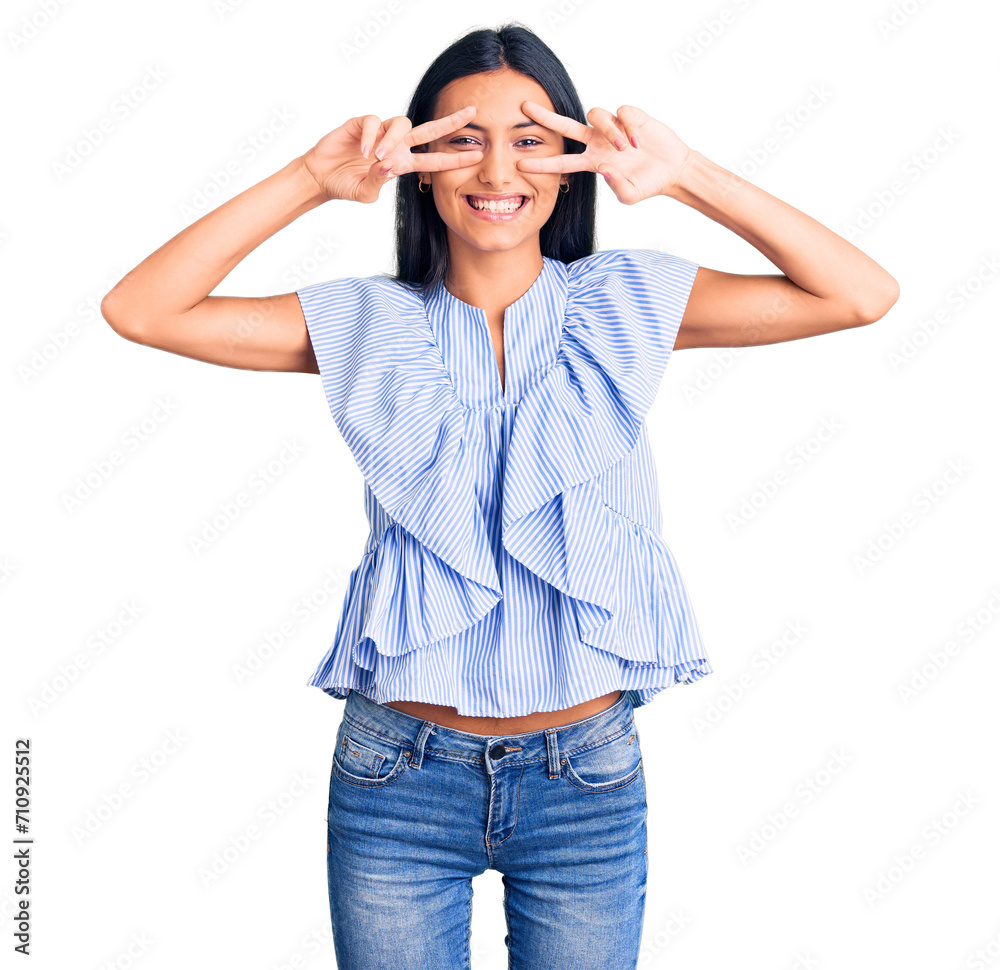 Young beautiful latin girl wearing casual clothes doing peace symbol with fingers over face, smiling cheerful showing victory Young beautiful latin girl wearing casual clothes doing peace symbol with fingers over face, smiling cheerful showing victory