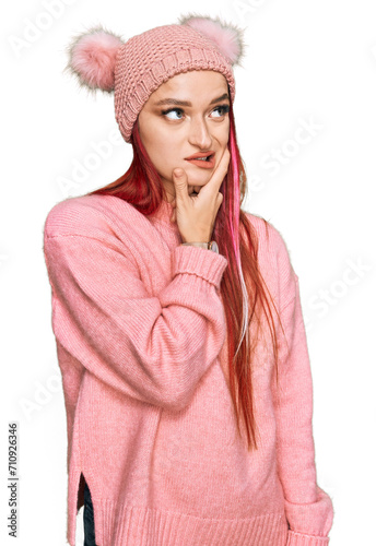 Young caucasian woman wearing casual clothes and wool cap thinking worried about a question, concerned and nervous with hand on chin