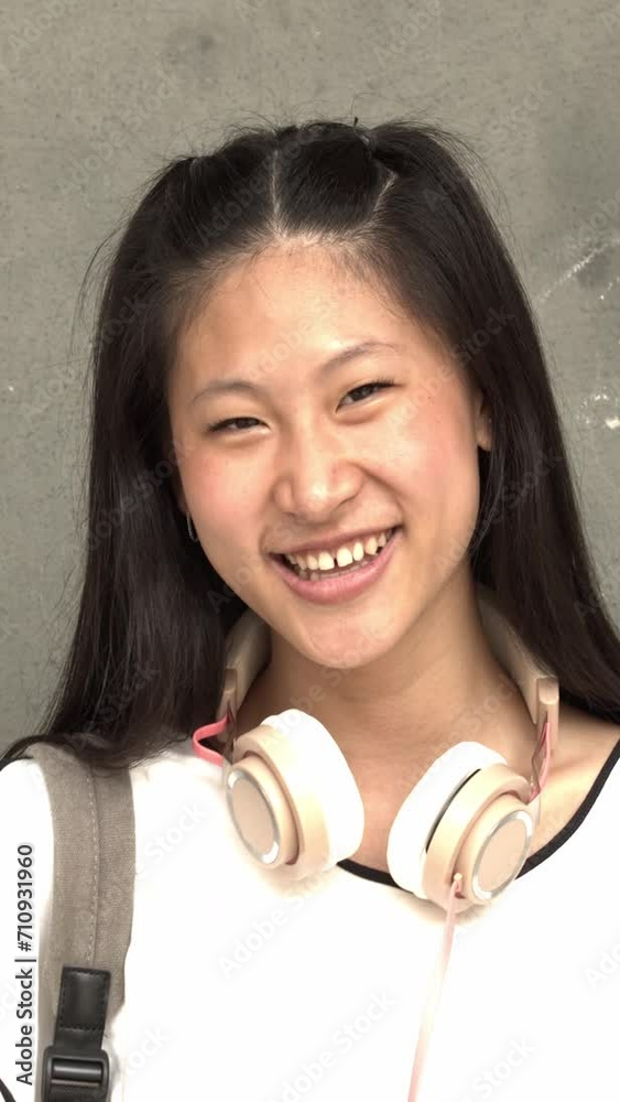 Vertical video. Portrait of Asian teenage student girl looking at camera smiling Vertical video. Portrait of Asian teenage student girl looking at camera smiling