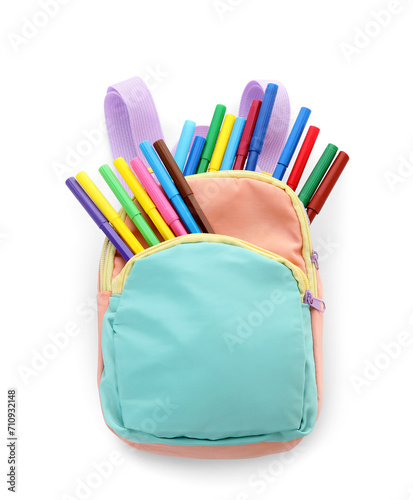 School backpack with different felt-tip pens on white background