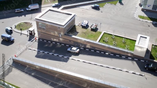 Two cars drive out of courtyard by marked paths, top view. photo