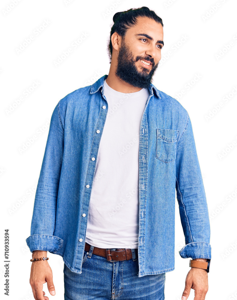 Young arab man wearing casual denim shirt looking away to side with smile on face, natural expression. laughing confident. Young arab man wearing casual denim shirt looking away to side with smile on face, natural expression. laughing confident.