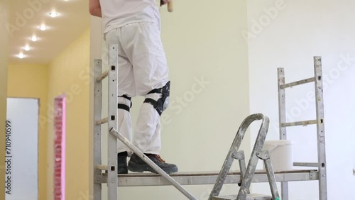 Worker in white uniform is going up on the scaffold. photo