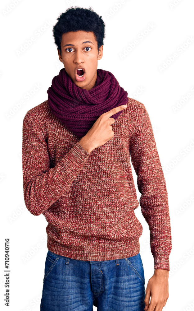 Φωτογραφία Young african american man wearing casual winter sweater and scarf surprised pointing with finger to the side, open mouth amazed expression