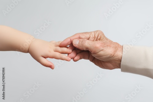 Hands of senior man and baby on white background