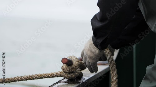 Close-up of hands tying boat with rope Boat secured by rope safety in water travel. Boat and rope essentials in sea journeys Quintessential scene of maritime life duo for safe sea travels. photo