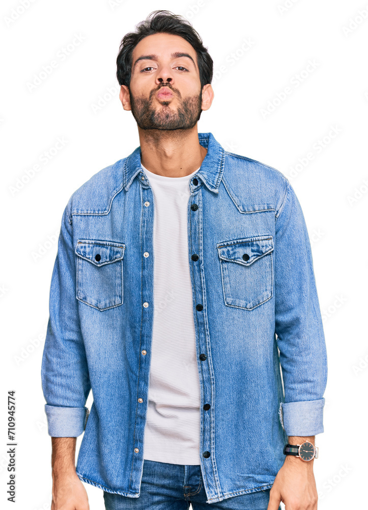 Young hispanic man wearing casual clothes looking at the camera blowing a kiss on air being lovely and sexy. love expression.