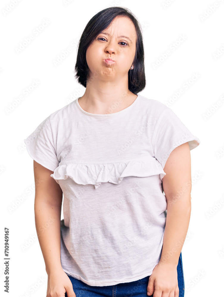 Brunette woman with down syndrome wearing casual white tshirt puffing cheeks with funny face. mouth inflated with air, crazy expression. Brunette woman with down syndrome wearing casual white tshirt puffing cheeks with funny face. mouth inflated with air, crazy expression.