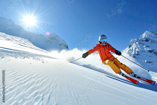 Skier in a brightly colored ski suit, racing down a snow slope on a sunny day.